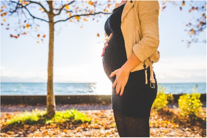 pregnant woman in front of water